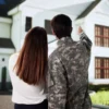 A house key and mortgage paperwork beside a veteran home loan rate chart