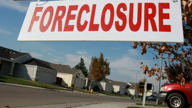Detroit Family Faces $10,000 HOA Bill and Possible Foreclosure After Brother-In-Law Misses Fees on Condos, Forcing Woman to Consider Selling $50,000 in Stocks A couple reviewing bills and investment account statements on a kitchen table