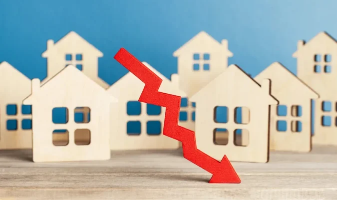 Why Economists Say a 2026 Housing Crash Looks Unlikely as U.S. Job Openings, Home Prices, Inventory and Mortgage Rates Hold in a Narrow Range For-sale homes with a real estate sign in a suburban neighborhood