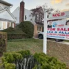 U.S. Home Prices Rose 2.1% in June as Chicago Led Large Metro Gains and 30-Year Mortgage Rates Stayed Near 6.5% A row of suburban homes with a for-sale sign and overcast sky