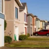 A for sale sign in front of a suburban home as mortgage rates rise