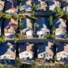 A for sale sign in front of a suburban home as mortgage rates rise