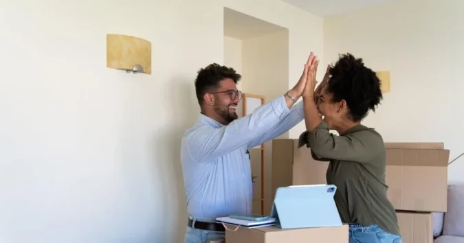 A couple reviews mortgage paperwork and homebuying assistance details at a kitchen table