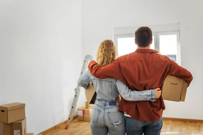 Down Payment Assistance Can Help Buyers Cover Closing Costs and Pair With FHA USDA or Conventional Loans as Middle Income Renters Miss Key Programs A couple reviews home financing papers with a lender at a kitchen table