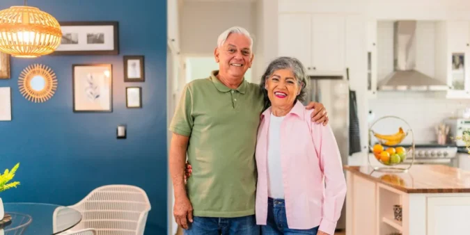 An older couple discusses home renovation plans in a bright kitchen with accessibility features
