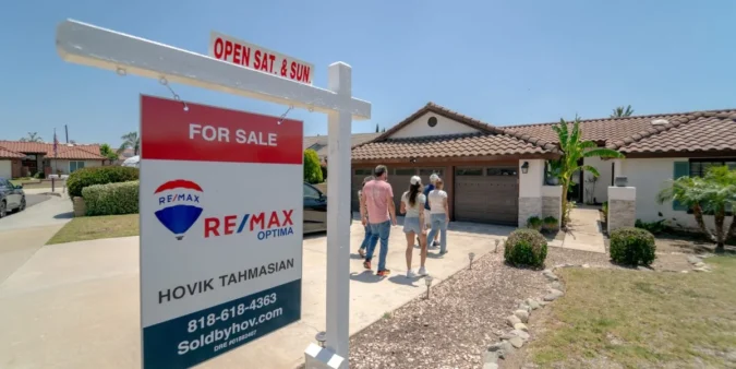 A for-sale home sign outside a house with the housing market under pressure from mortgage rates