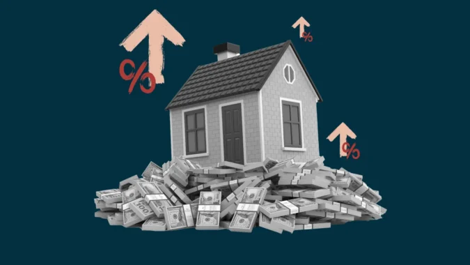 A row of suburban houses with mortgage rate charts and a calculator in the foreground