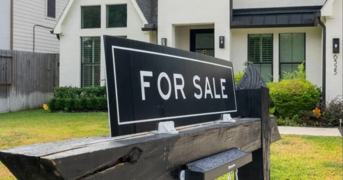 A home for sale sign in front of a suburban house with mortgage rate figures overlaid