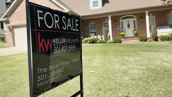 A for sale sign outside a home as higher mortgage rates raise monthly costs for Arkansas buyers