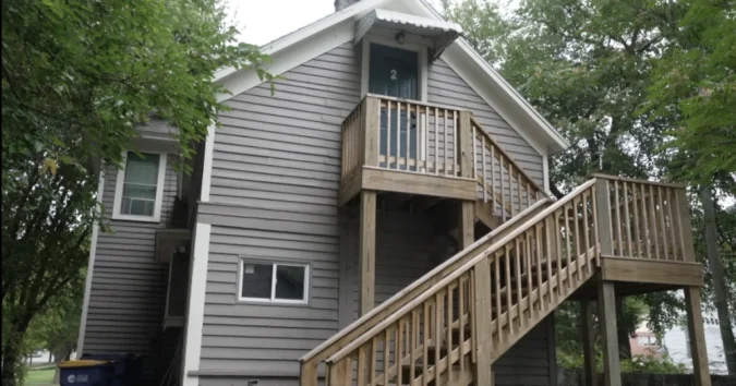 A tenant writes a rent check as Michigan landlords are required to offer a fee-free payment option