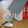 VA Says Veterans Can Reuse Home Loan Entitlement and May Be Leaving Six-Figure Benefits Untapped When Buying Another House A veteran with house keys in front of a suburban home