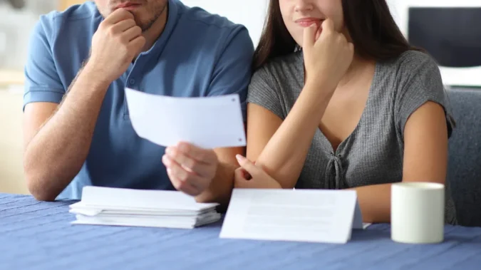 A calculator, house keys and mortgage paperwork on a table