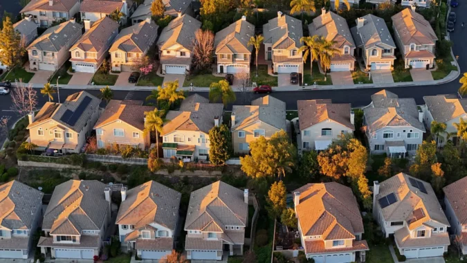 A for sale sign in front of a house as mortgage rates rise and demand falls