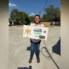 Two San Antonio women share an emotional moment beside a vehicle after a Cash for Kindness award