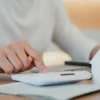 First-Time Homebuyers Weigh Mortgage Points Against Later Refinancing as Reddit Thread Breaks Down Break Even Math and Loan Costs A person reviews mortgage papers while comparing upfront points and future refinancing costs