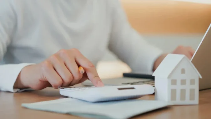 First-Time Homebuyers Weigh Mortgage Points Against Later Refinancing as Reddit Thread Breaks Down Break Even Math and Loan Costs A person reviews mortgage papers while comparing upfront points and future refinancing costs