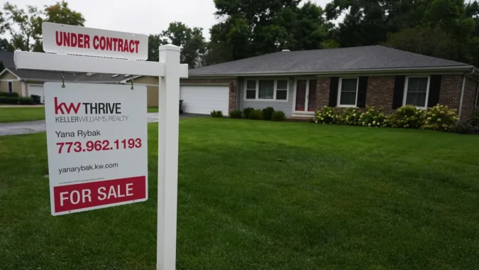 A for sale sign outside a suburban home with higher mortgage rates weighing on buyers
